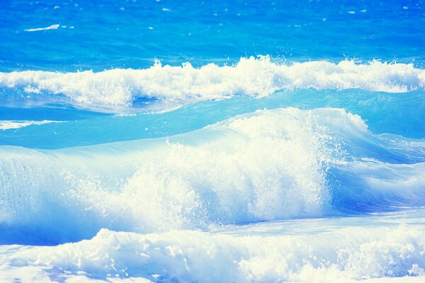 Die Wellen des blauen Ozeans brechen an der Küste auf