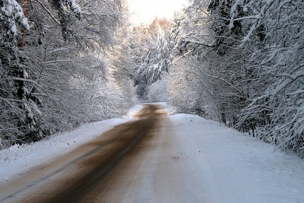 A road strewn with sand on a snowy day