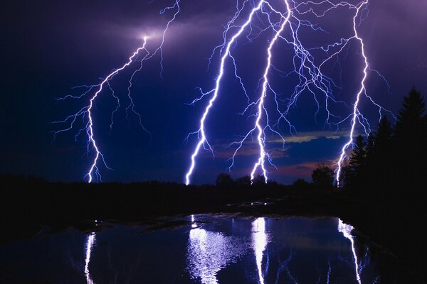 The night sky is cut by lightning arrows going into the ground