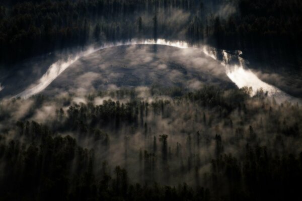 Sobre el río y el denso bosque se extiende la niebla