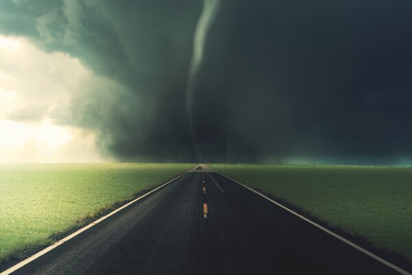 En los campos verdes en el camino negro Tornado