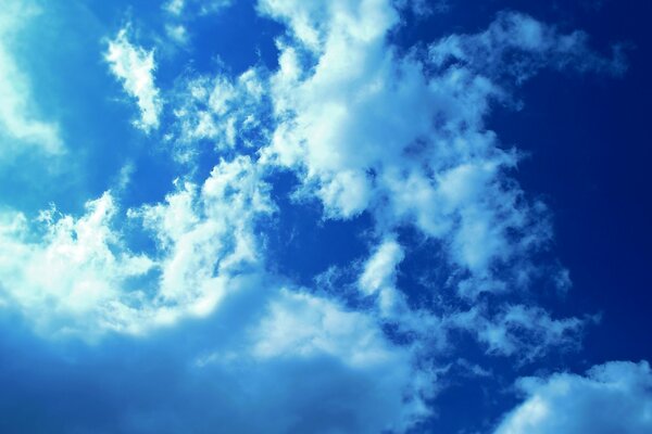 Light in the blue sky through the cotton wool of white clouds