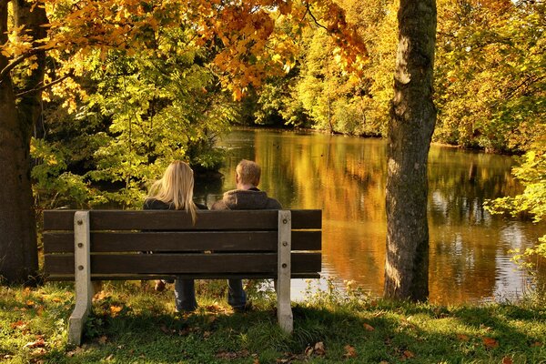 Ragazzo e ragazza sulla passeggiata nel parco in autunno dorato