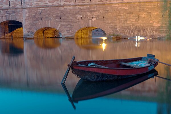 Barca sulla superficie dell acqua serale del canale vicino al ponte di Strasburgo