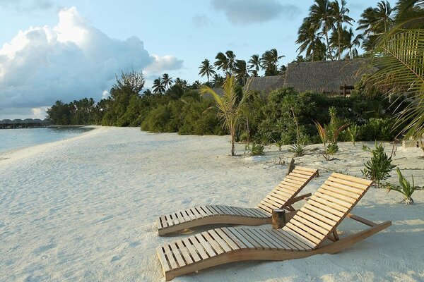 Sandy beach with wooden sun beds