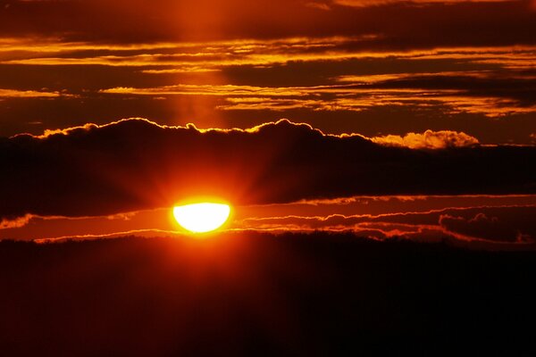 Purpurroter Sonnenuntergang. Die Sonne hinter den Wolken