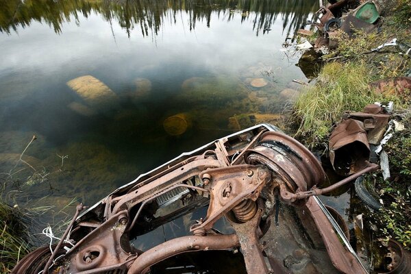 Discarica di auto in una pozzanghera di immondizia