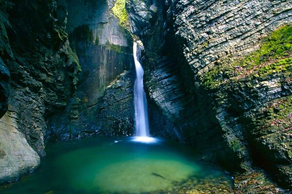 Una cascata splendente scorre dalle rocce