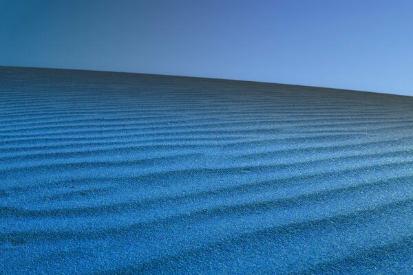 Blauer Wüstensand mit klarem Himmel