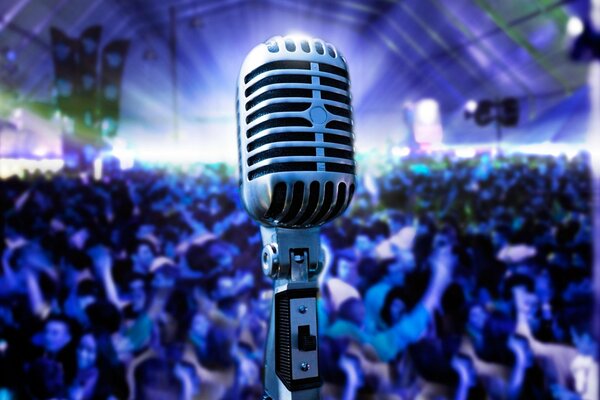 Photo of a microphone against the background of a dancing crowd in the hall