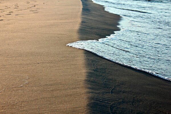 Морская пена на песчаном берегу