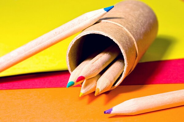 Crayons de couleur dans une boîte à crayons sur papier de couleur