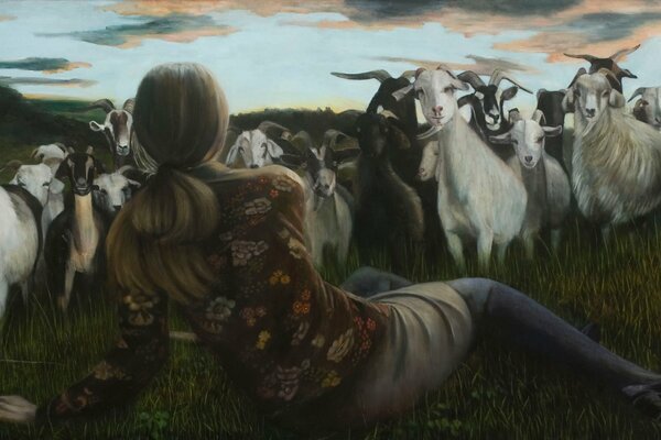Dziewczyna leżąca na łące i owce pasące się na łące patrzą na siebie