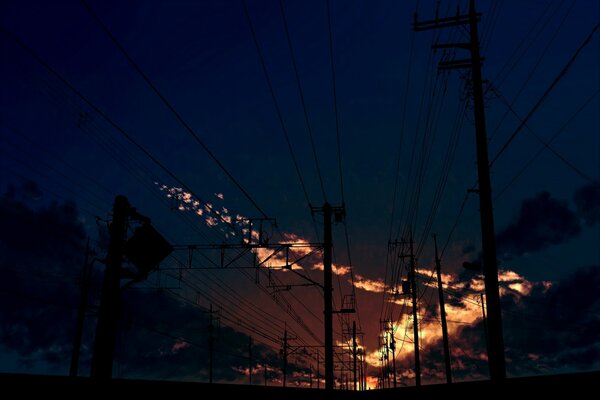 Coucher de soleil ardent parmi les poteaux électriques