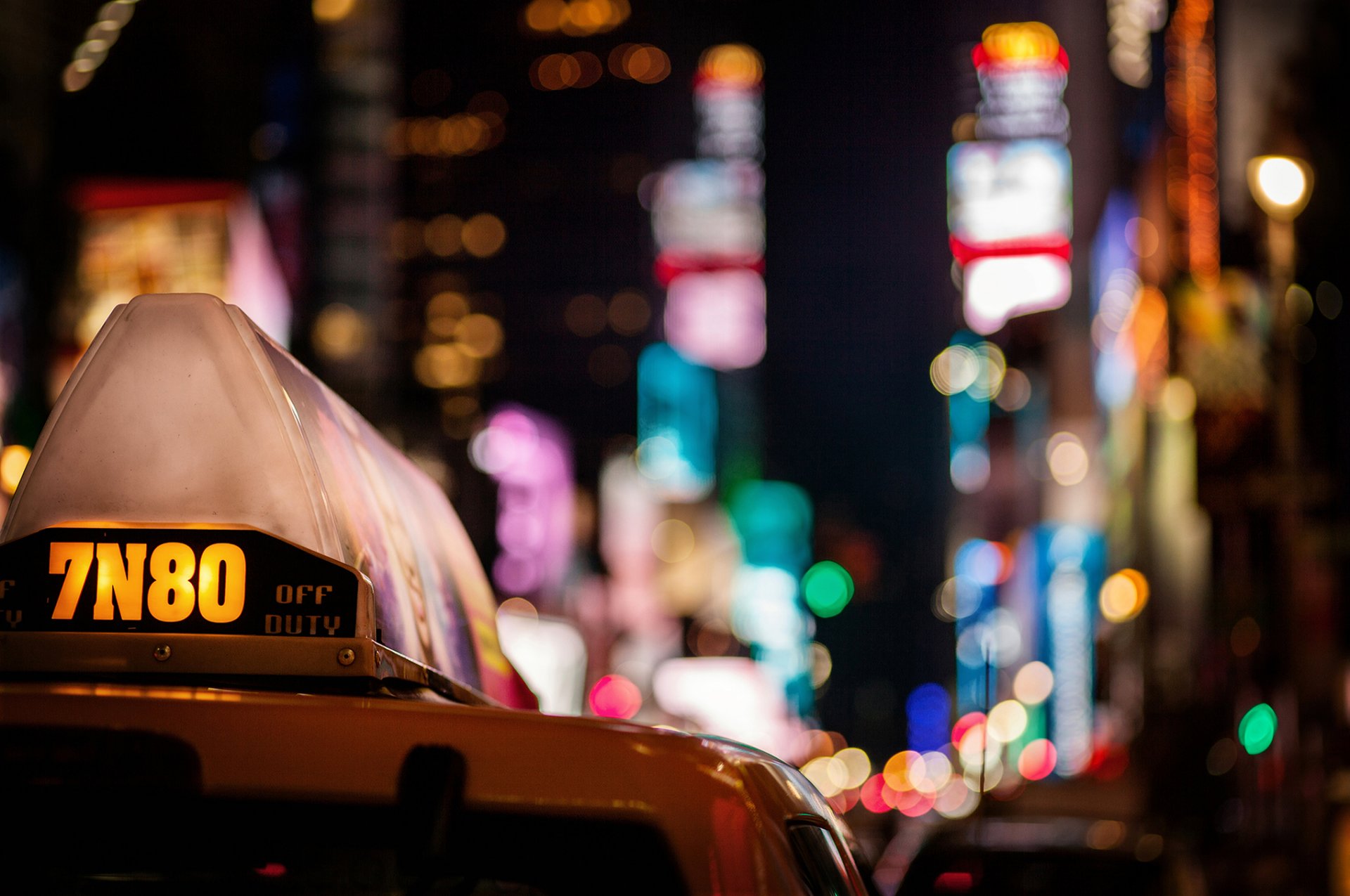 taxi coche ciudad noche rascacielos luces multicolor bokeh