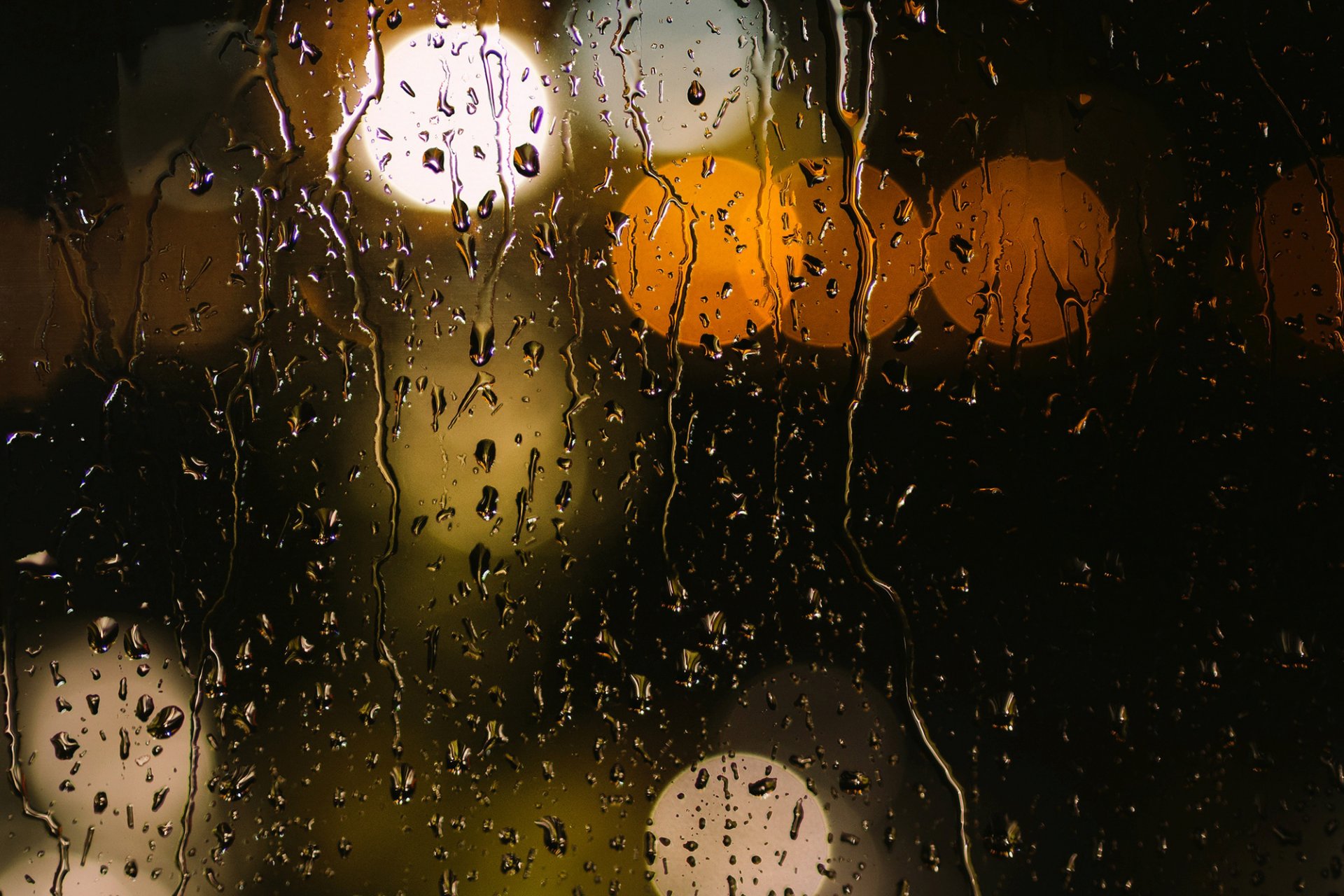 gros plan bokeh lumières orange jaune verre gouttes eau pluie