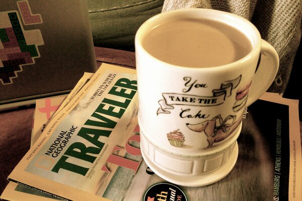 Tasse avec latte debout sur les magazines