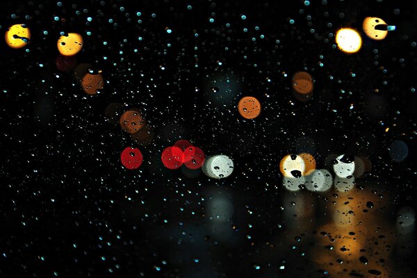 Small raindrops on the glass with city lights