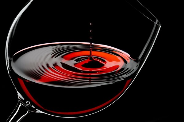 A glass of red wine on a black background