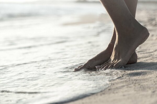 Bare feet sea foam sandy beach