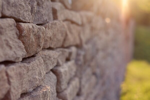 Pared de piedra iluminada por los rayos del sol