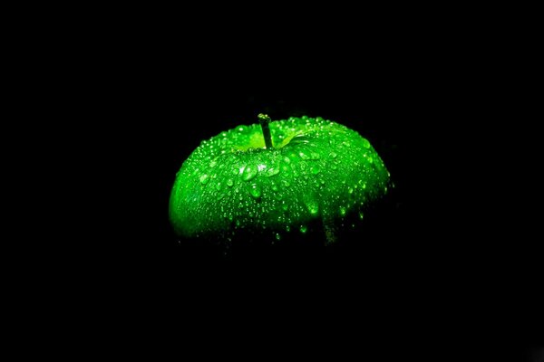 Gotas en una manzana sobre un fondo negro