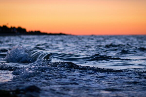 Vagues du soir sur fond de coucher de soleil