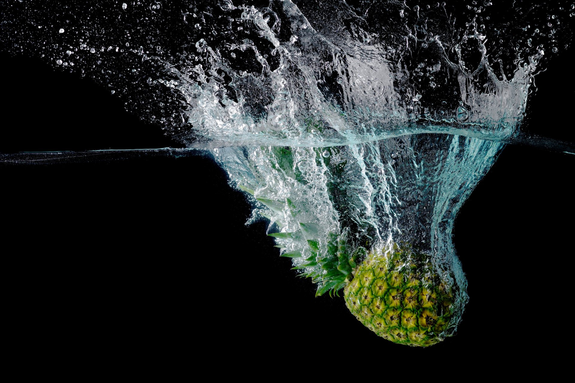 pineapple fruit close up water spray black background