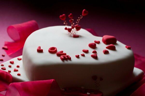 Torta a forma di cuore ricoperta di mastice bianco con la scritta Love