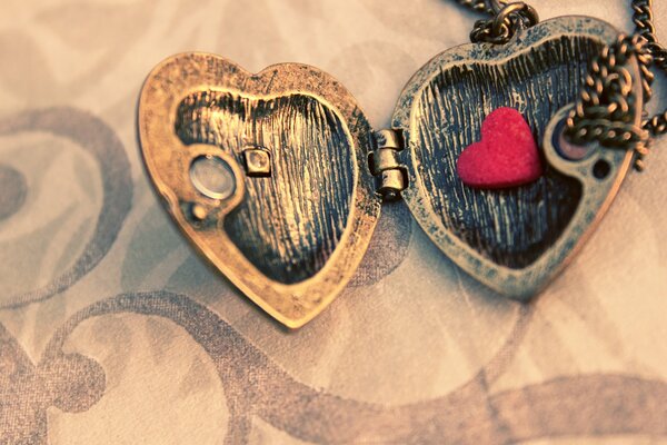 Pendentif sur une chaîne en forme de coeur et avec un petit coeur à l intérieur