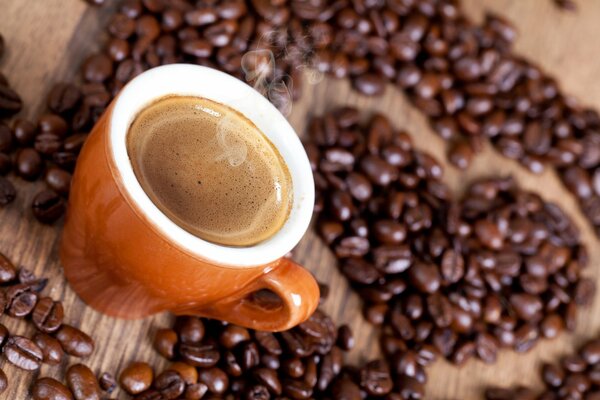 Tasse de café chaud sur fond de coeur de grains de café