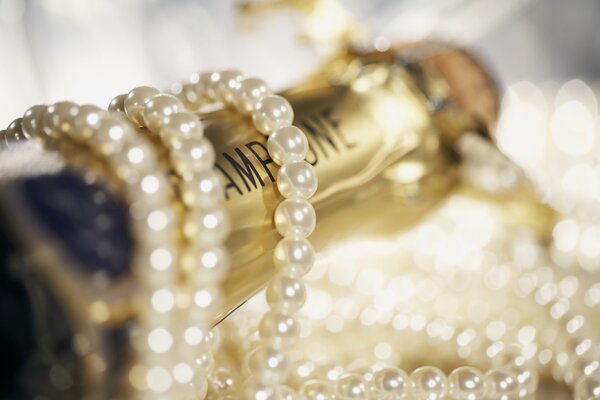 Pearl beads wrapped around a bottle of champagne