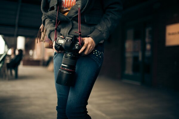 Fille dans les mains avec un appareil photo canon