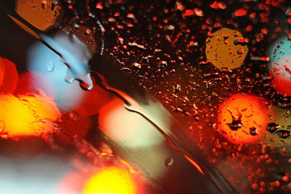 Multicolored drops on the glass at night