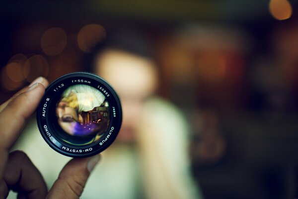 Hand with the lens. Macro shooting with bokeh effect