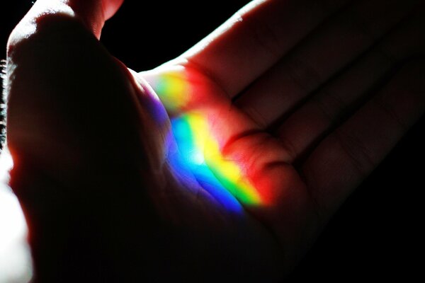 A rainbow is visible on the hand