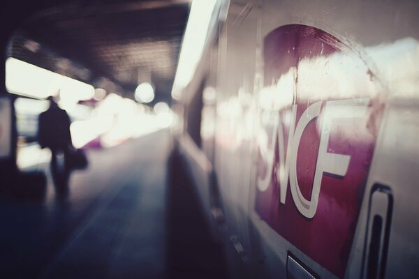 Homme avec une mallette à côté d un train de métro dans une image floue