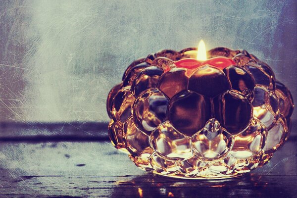 A candle burns in a glass candlestick