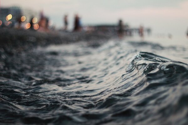 The lights of the city are reflected in the sea