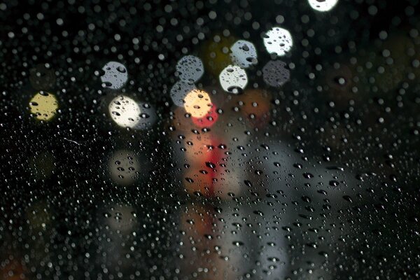 Raindrops glisten on the glass