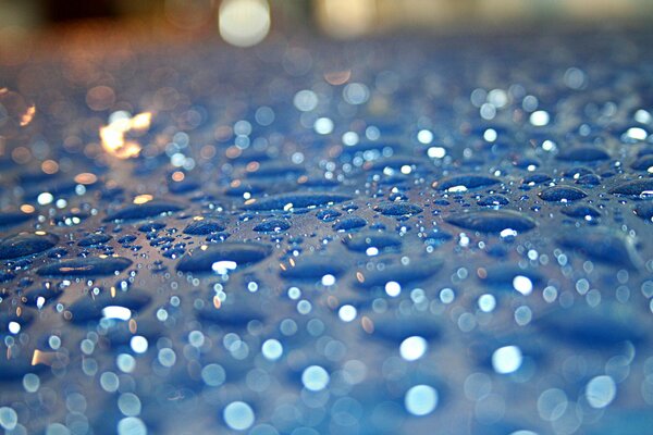 Regentropfen auf blauem Glas