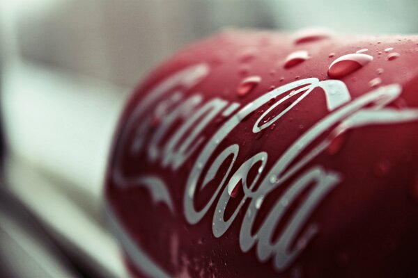 Lata de Coca cola refrigerada con gotas de agua