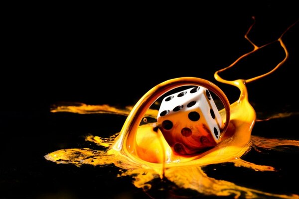 A cube in yellow picturesque splashes on a black background