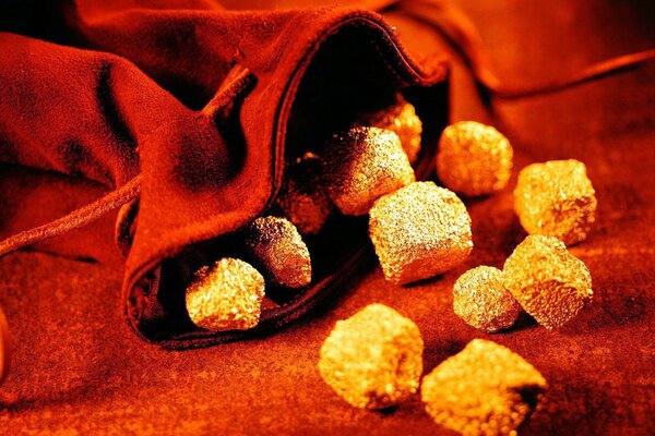 Una dispersione di pietre d oro da un sacchetto rosso