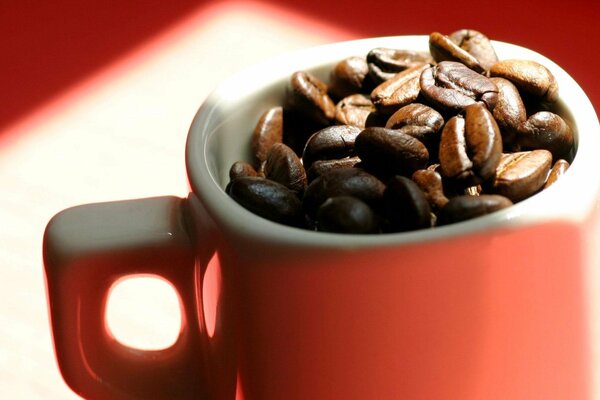 Red mug filled with coffee beans