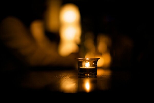 Burning candles stand on the wooden floor