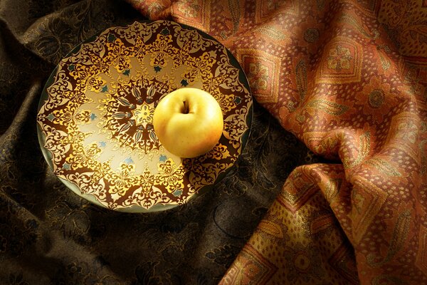 Yellow apple, on a painted bowl