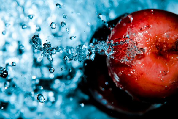 Roter Apfel in Wassertropfen