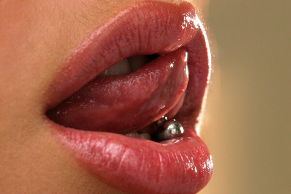 Weibliche Lippen und Zunge mit grobem Piercing