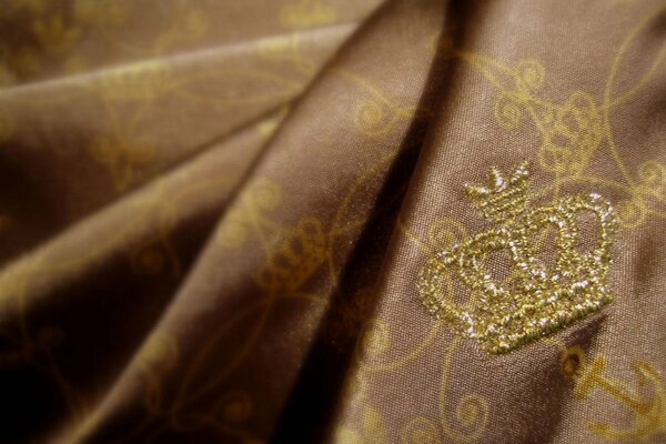 Embroidered crown on rich fabric